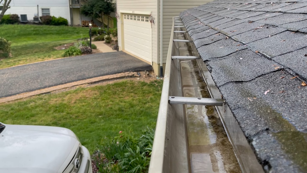 Open roof gutter after gutter cleaning, showing clear water flow path