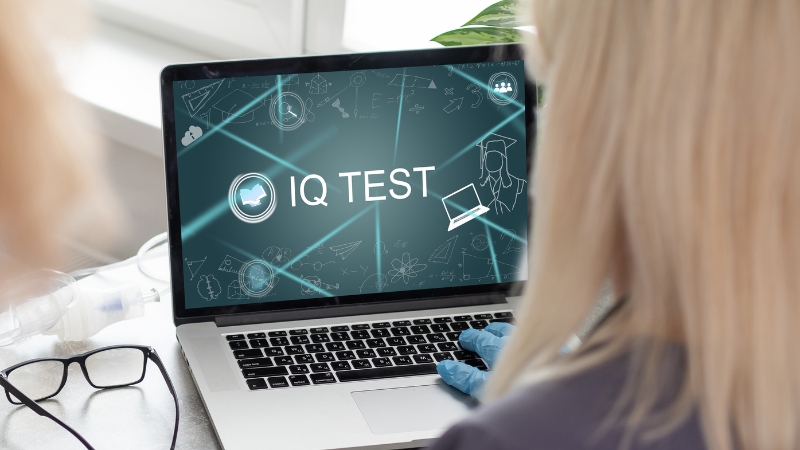 Person sits at a laptop that displays an online IQ test on the screen