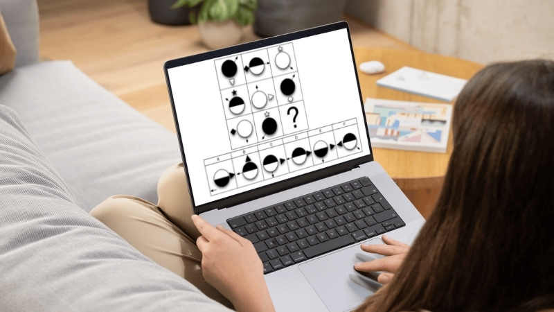Person uses a laptop to solve a pattern-based IQ test with multiple choice answers